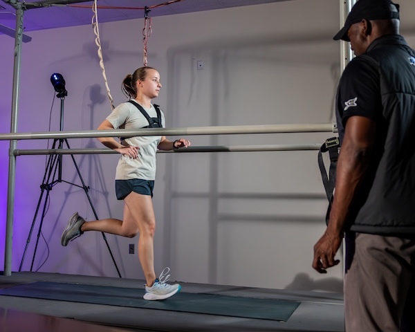 Person observes runner on treadmill