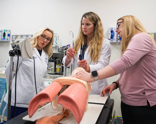 Faculty and student observing a medical monitor in simulation lab