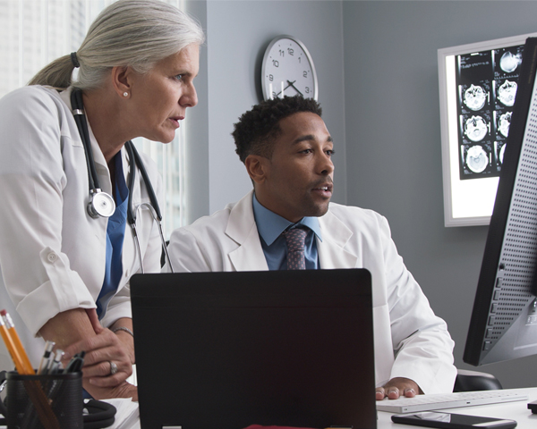 Two medical professionals looking at monitor