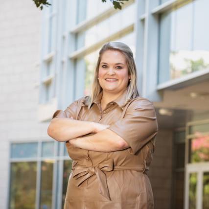 A business student in front of a building