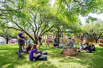 A professor teaching students in an outdoor space