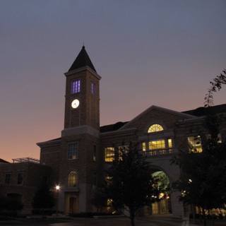 The clock tower at TCU's Brown Lupton University Union glows at dusk
