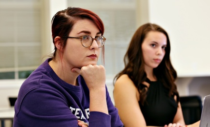 Two graduate students listen intently in an education class at TCU