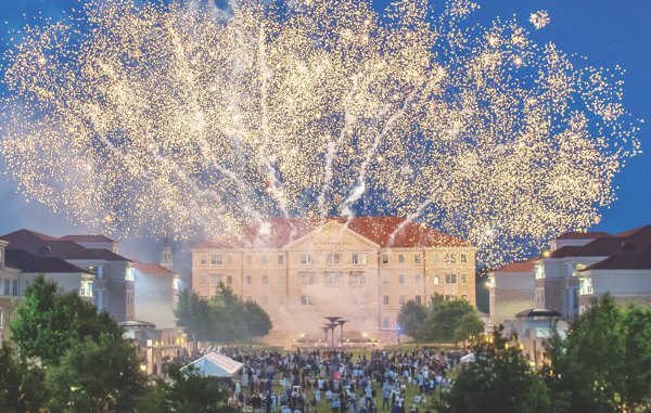 Fireworks exploding above a crowd gathered in the Campus Commons