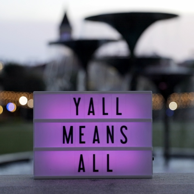 Y'all Means All sign in front of Frog Fountain