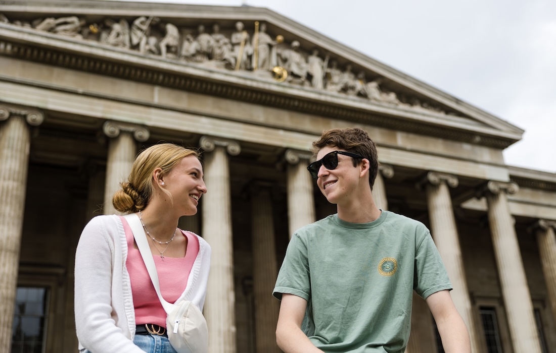 A female and male student sitting in front of the British Museum