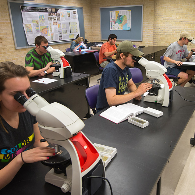 Geology students study samples under microscopes