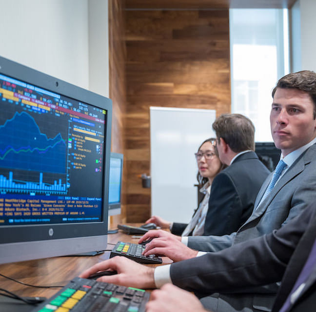 Business Analytics students review reports in a computer lab