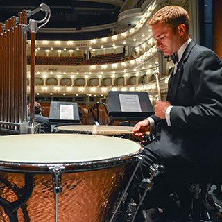 A male TCU music student in a tuxedo rehearses percussion at Fort Worth's Bass Performance Hall