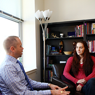Rev. Todd Boling of TCU Religious and Spiritual Life talks to a student in his office.