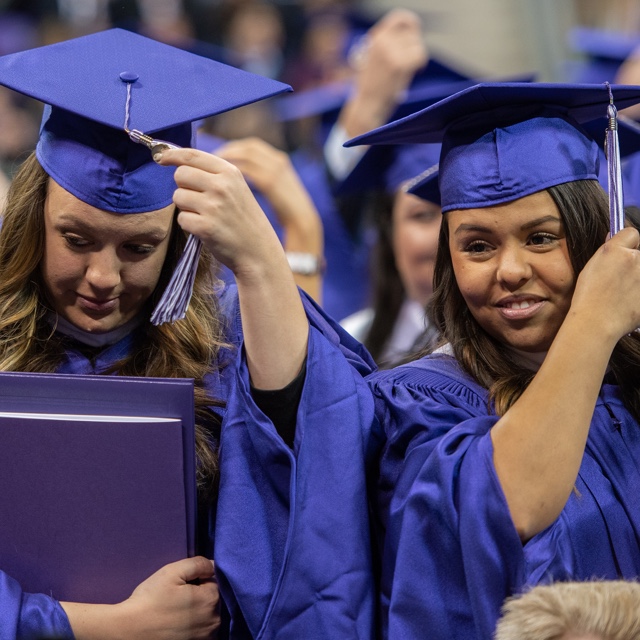 two girls moving their tassels to the side