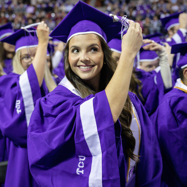TCU graduate moving her tassel over on her graduation cap