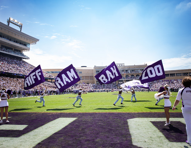 Members of the Rangers spirit team run across the field carrying flags