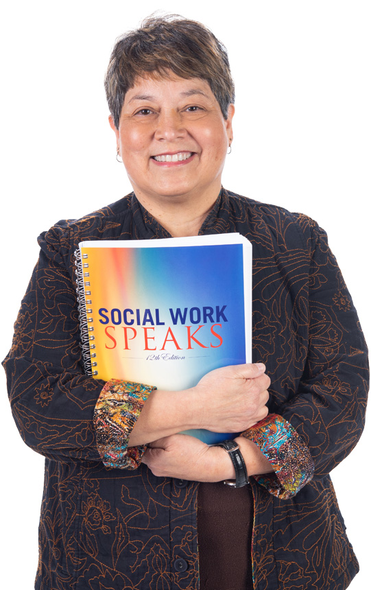 Lynn Jackson, holding a copy of Social Work Speaks