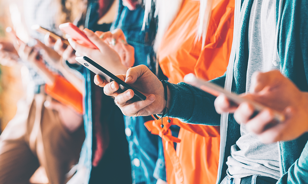 many hands holding a variety of personal devices