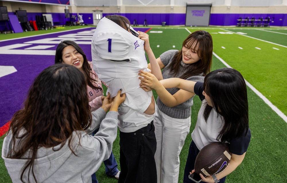 Students try on football uniforms