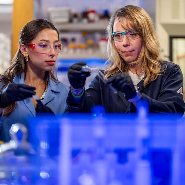 Kayla Green works in a lab with a student