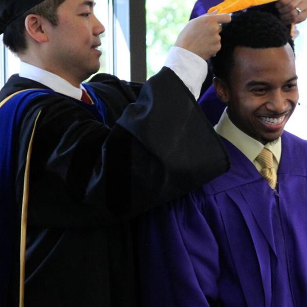 Professor Johnny Nhan performs a hooding ceremony for criminal justice master's graduates