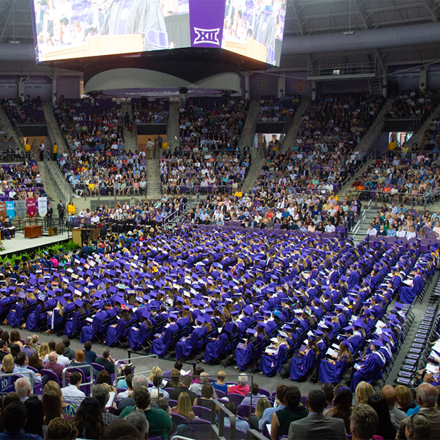 Graduates in purple regalia gathered in the coliseum