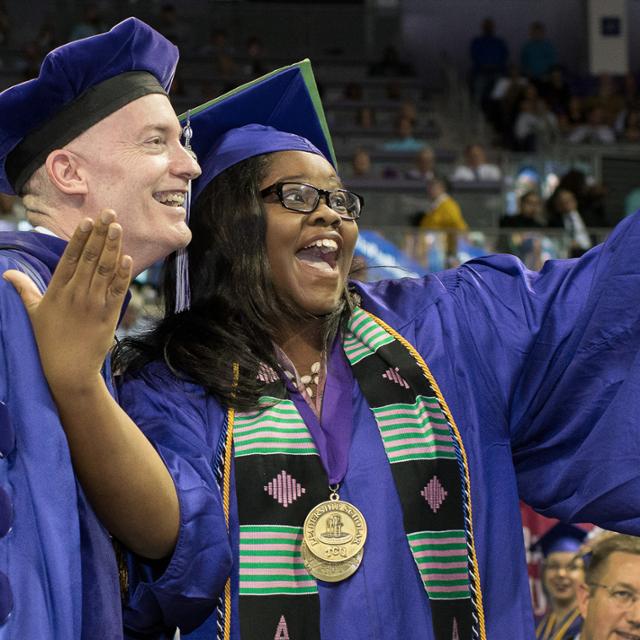 A graduate takes a selfie with Chancellor Victor J. Boschini, Jr. at a previous commencement ceremony. (Photo by Glen E. Ellman)