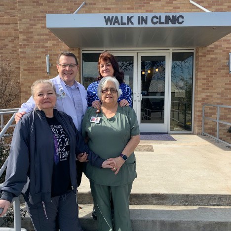 Staff and patients stand in front of a rural health clinic